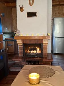 a fireplace in a living room with a table with a candle at Centrum Wypoczynkowe Karman in Gdańsk