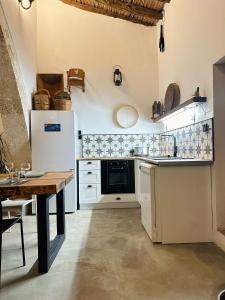 a kitchen with white appliances and a wooden table at The Hermitage: Timeless charm&Beach&History nearby in Yenibosazici