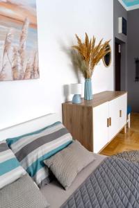 a bedroom with a bed and a vase with a plant at Tiffany Apartment in Novi Sad