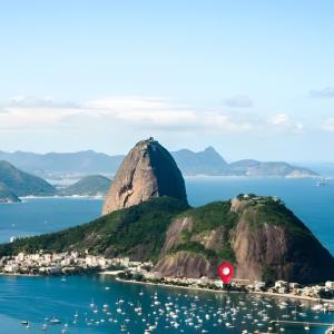 Una montaña en el agua con una señal roja. en STUDIOS URCA na rua da mureta da Urca, en Río de Janeiro