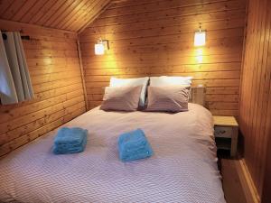 a bedroom with a bed with two towels on it at Chalet Pura Vida - En pleine nature, tout confort in Le Valtin