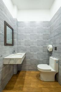 uma casa de banho com um WC, um lavatório e um espelho. em Richy Dalat Hotel em Da Lat