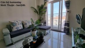 a living room with a couch and a glass table at heri24h-Apartment Homestay Ninh Thuận - Căn Hộ Phan Rang in Kinh Dinh
