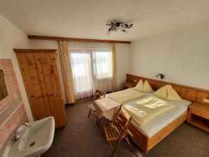 1 dormitorio con cama, lavabo y bañera en Appartements Binderhof, en Kirchdorf in Tirol