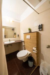 a bathroom with a toilet and a sink at Lords Midtown Suites Bangalore in Bengaluru