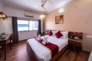 Un dormitorio con una cama con dos ositos de peluche. en Midtown Suites Marathahalli Bangalore, en Bangalore