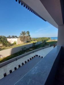 uma vista para a praia a partir da varanda de uma casa em The Wave residence Chott Meriam Sousse em El Ahmar