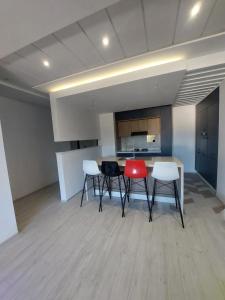 El AhmarにあるThe Wave residence Chott Meriam Sousseのテーブルと椅子2脚、キッチンが備わる客室です。