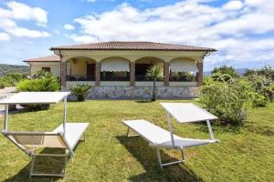 uma casa com duas mesas de piquenique no quintal em Alghero Villa Mistral per 7 persone Terrazza BBQ AC WiFi em Alghero