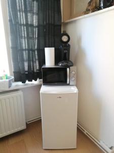 a microwave sitting on top of a white refrigerator at Chambre 2/4p confortable in Ostend