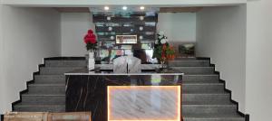 un vestíbulo con una escalera con una mesa y flores en HOTEL CREST PLAZA RESORT, en Pahalgām