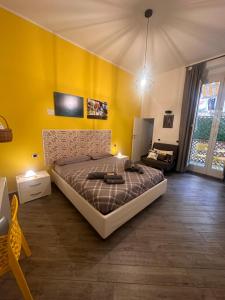 um quarto com uma cama e uma parede amarela em B&B Cosmoneapolitan em Nápoles