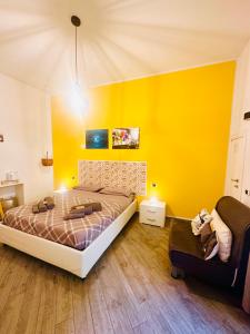 een slaapkamer met een bed en een gele muur bij B&B Cosmoneapolitan in Napels