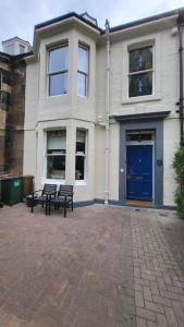 a building with two benches in front of it at Mackenzie Guest house in Edinburgh