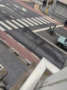 a person riding a bike on a street with a car at Studio 2/4p avec salle de bain privé in Ostend