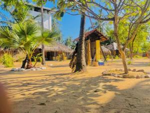 a resort with palm trees and a building on a beach at LANKATHILAKA KITESURFING HOLIDAY RESORT in Kalpitiya