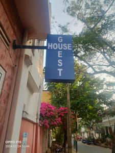 un cartel azul de la casa en un lado de un edificio en 25 guest house, en Pondicherry