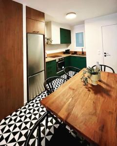 a kitchen with a wooden table and green cabinets at Lumiere I (Lena) in Ioannina