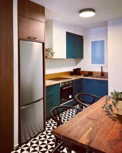 a kitchen with blue cabinets and a table with chairs at Lumiere I (Lena) in Ioannina