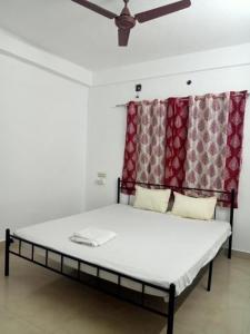 a bed in a room with a ceiling fan at 25 guest house in Puducherry