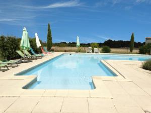a swimming pool with chairs and umbrellas at La Galerie gîte climatisé 4 chambres 8 personnes, 2 salles d'eau, 2 WC, WIFI, parking, piscine chauffée à partager, animaux acceptés, Gîte en pleine nature in Lorignac
