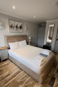 a bedroom with a large bed with white sheets at Maple, Country Chalet in Pegsdon in Hexton