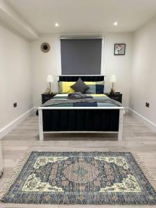 a bedroom with a large bed and a rug at Lovely Studio Ealing in London