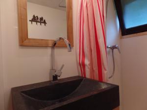 サン・ジェルヴェ・レ・バンにあるChalet Le Paddockのバスルーム(黒いシンク、赤いシャワーカーテン付)