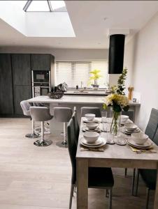 una cocina con una mesa con platos y flores. en New, modern 4 bed, 3 bath house ,free parking en Oxford