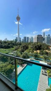 een balkon met een zwembad en uitzicht op de skyline van Seattle bij Suasana Bukit Ceylon Residence in Kuala Lumpur