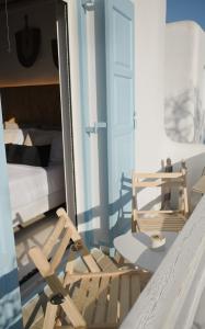a room with a chair and a bed and a mirror at NISOS Home Stay in Mýkonos City