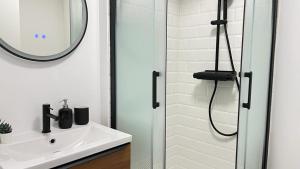 a bathroom with a sink and a shower with a mirror at Le bohème in La Houssaye-en-Brie +18 photos