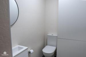 a white bathroom with a toilet and a sink at Navio Beach Apartment Santa Cruz in Santa Cruz +41 photos