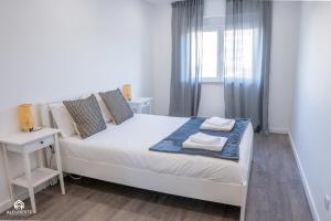 sypialnia z białym łóżkiem i oknem w obiekcie Navio Beach Apartment Santa Cruz w mieście Santa Cruz