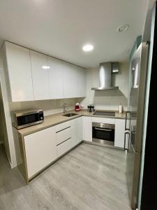 a kitchen with white cabinets and stainless steel appliances at La Casa del Abuelo in Tudela