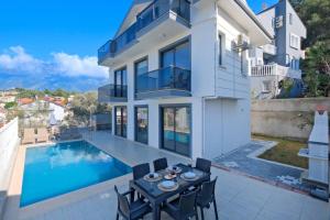 a villa with a swimming pool and a table and chairs at Villa Simge 3+1 Ölüdeniz in Fethiye