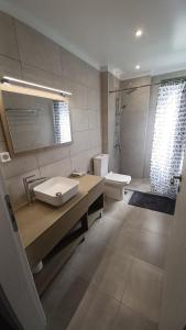 ein Bad mit einem Waschbecken, einem WC und einer Dusche in der Unterkunft MILIASIA in Kondáraina