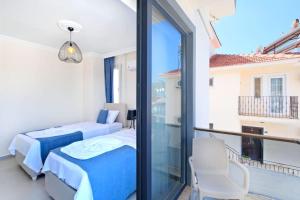 a bedroom with two beds and a balcony at Villa Simge 3+1 Ölüdeniz in Fethiye +15 photos