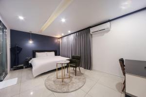 - une chambre avec un lit, une table et une chaise dans l'établissement ON:NA Hotel, à Busan