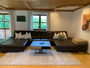 a living room with a leather couch and a coffee table at Habicht Ferienhaus in Arnbruck