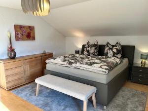1 dormitorio con cama y banco. en Habicht Ferienhaus, en Arnbruck