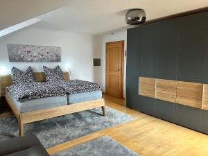 1 dormitorio con 1 cama con almohadas blancas y negras en Habicht Ferienhaus, en Arnbruck