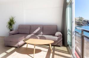 ein Wohnzimmer mit Sofa und Tisch in der Unterkunft MAR Suites OnlyMalaga in Benalmádena