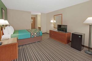 um quarto de hotel com uma cama e uma televisão de ecrã plano em Baymont Inn & Suites Richmond em Richmond