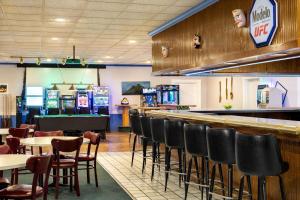 a restaurant with a bar and tables and chairs at Ramada by Wyndham Richland Center in Richland Center