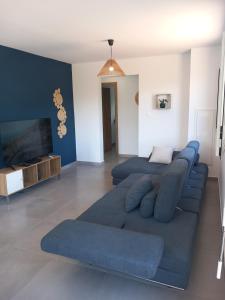 a living room with a blue couch and a tv at Ti kaz Salazie 1 in Salazie