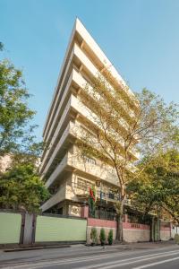 un edificio alto con un árbol delante de él en Arnna Hotel- Goregaon East, en Bombay