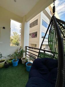 uma rede de descanso numa varanda com vasos de plantas em Your cozy home em Dehradun