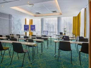 a conference room with tables and chairs and yellow curtains at Novotel Paris 17 in Paris