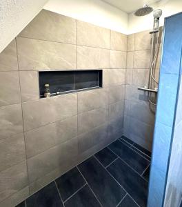 ノルトダイヒにあるAuszeit Norddeich mit Seeblickのタイルフロアのバスルーム(シャワー付)